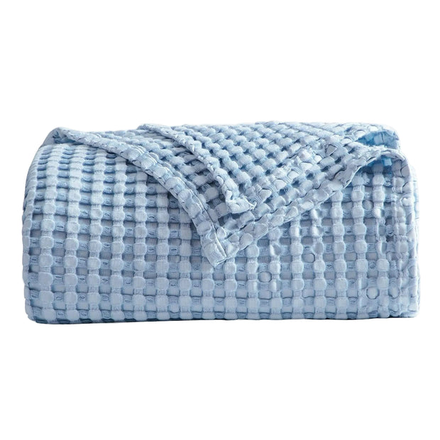 Folded blue textured blanket on a white background