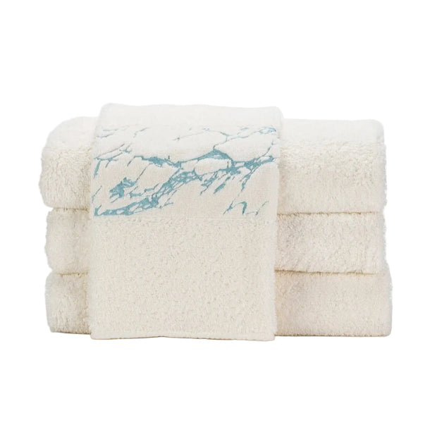 Stack of white towels with blue marble pattern on a white background